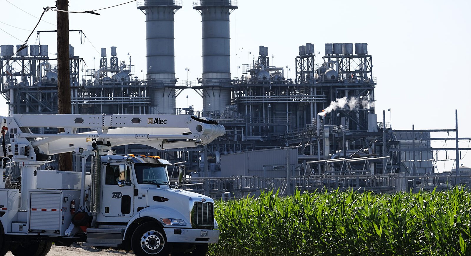 Walnut energy center with line truck out in front and corn field in front