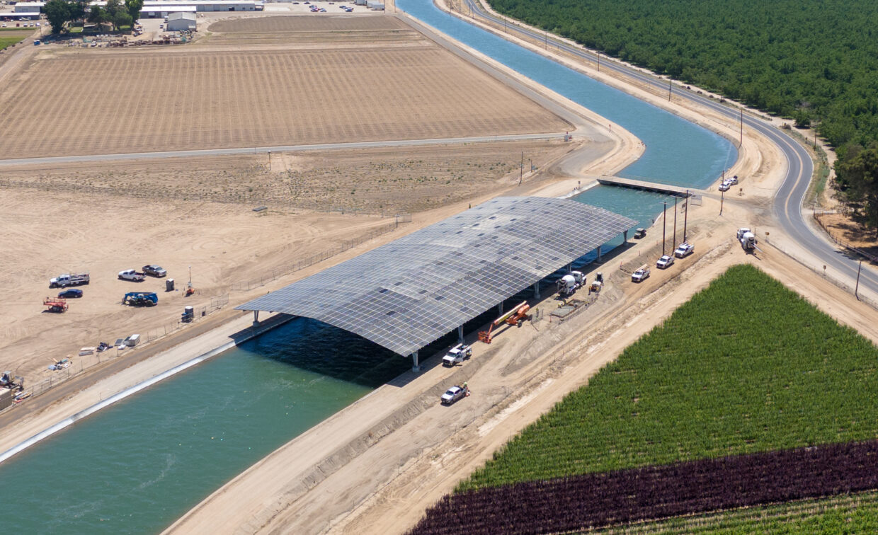 Wide aerial photo of solar canopy structure over large irrigation canal.