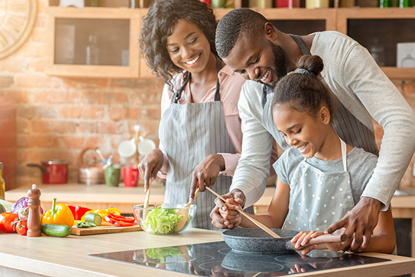 Happy family cooking with electricity