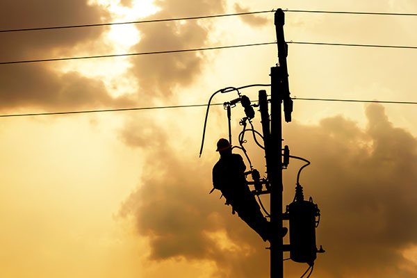 a power lineman fixing an electric pole