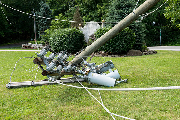 a broken electrical pole laying on grass