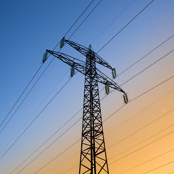 Electric power lines against blue and yellow sky.