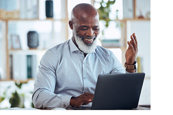 Elderly black man smiles while using his laptop for business rebates