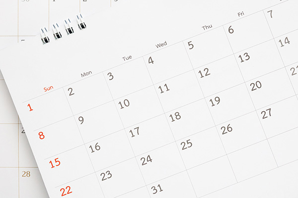 calendar page close up on blue background business planning appointment meeting concept