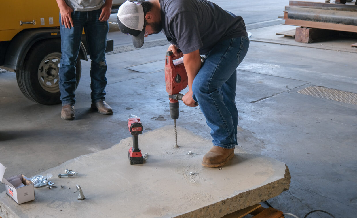 Students operates a power drill under supervision.