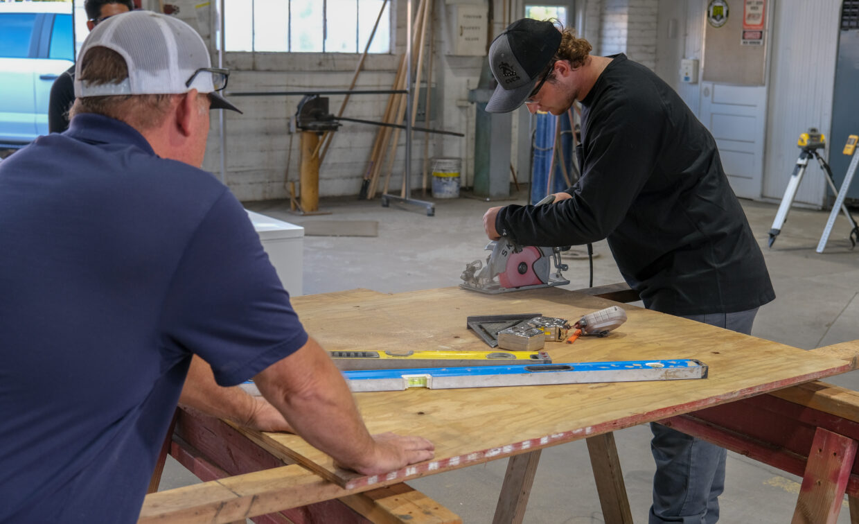 Students practices using a saw under supervision.